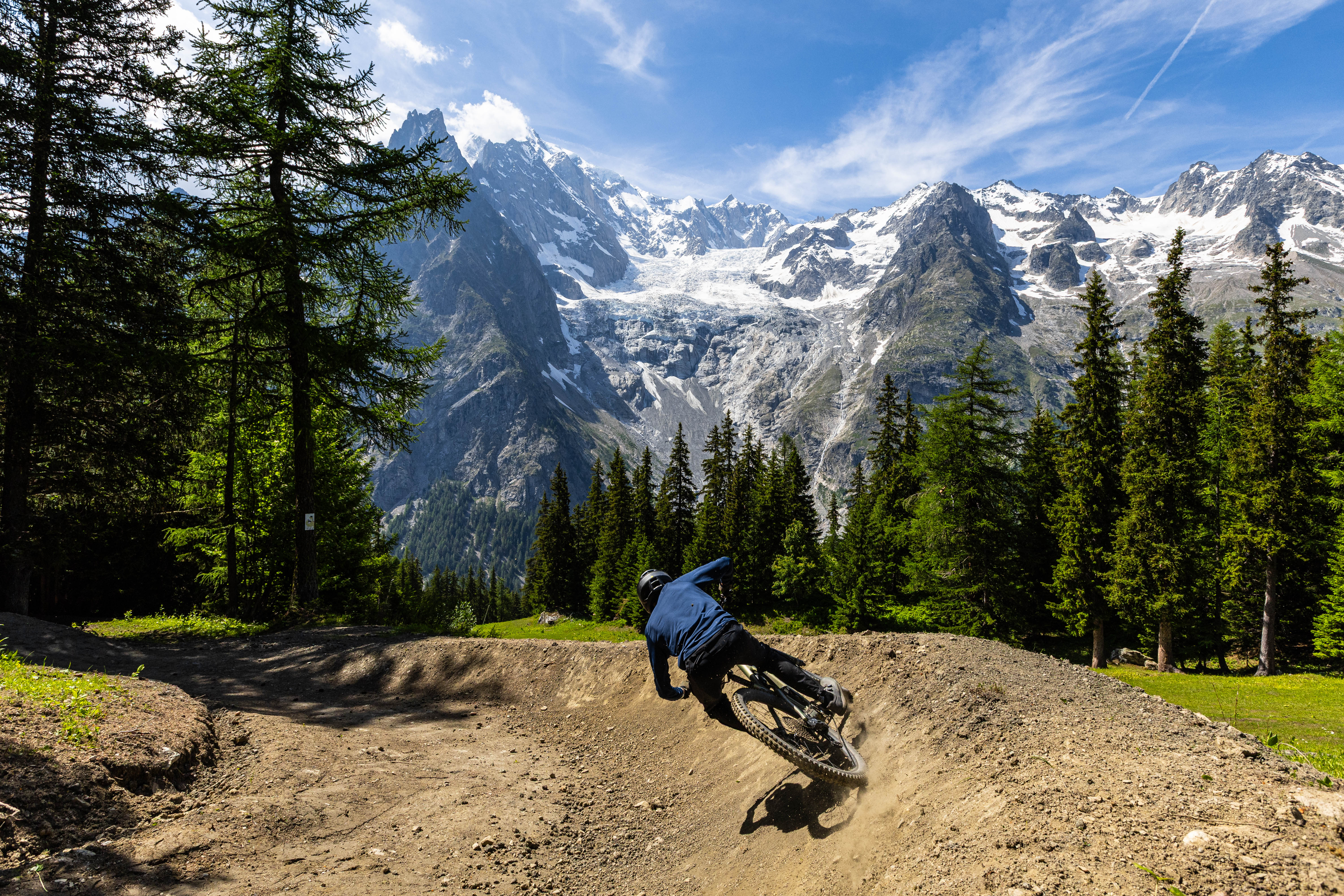 THE BIKE AREA
At the foot of majestic Mont Blanc, the Courmayeur Mont Blanc Bike Area once again confirms itself as the ideal destination for experiencing the mountains on two wheels in summer 2026. Despite ongoing construction work for the new Maison Vielle cabin lift and the replacement of the Checrouit cabin lift, in preparation for the 2026/27 winter season, the area remains ready to welcome bikers with plenty of opportunities for fun.
Across the slopes of Val Veny and Chécrouit, a wide range of options is available, designed both for those seeking the adrenaline of mountain biking and for e-bike enthusiasts: flow trails, panoramic routes, and loops dedicated to both climbing and descending, offering a complete and accessible experience.
For summer 2026, three lifts will be in operation — the Dolonne cabin lift, the Val Veny cable car, and the Zerotta chairlift — along with a convenient electric shuttle service connecting the two areas, making it easy to reach high-altitude trails.
Discover more
